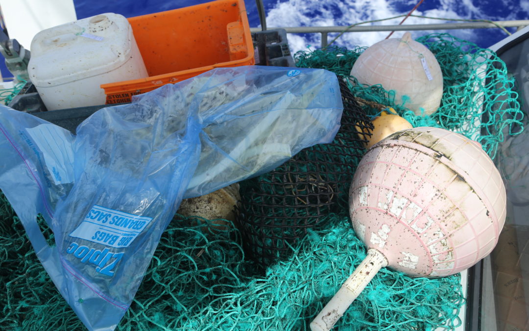Plastic fishing net, buoys, buckets and jugs in a pile on a boat