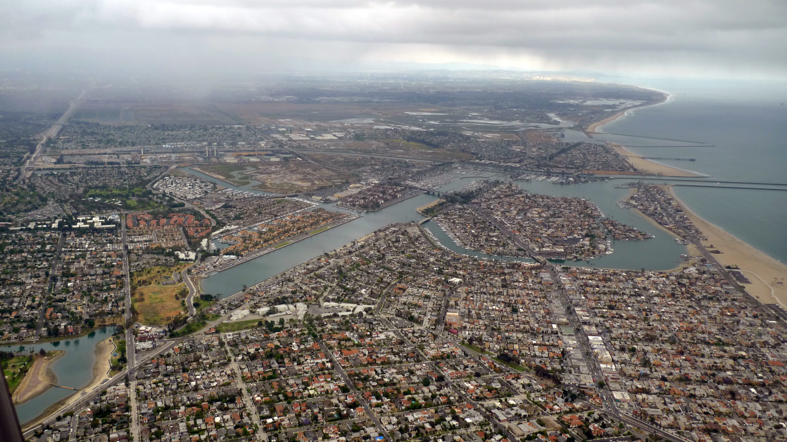 Aerial view of a coastline, including Alamitos Bay, on a cloudy day.