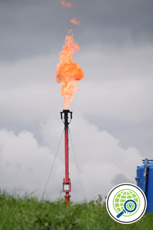 A red pipe sticking up from the ground emitting a large flame.