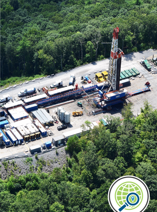 A fracking well pad with containers and equipment sits among trees.A fracking well pad with containers and equipment sits among trees.