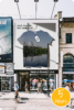 Advertisement above store shows tshirt with $10 price tag and image of polluted water and factory printed on it. Text says "What does the shirt really cost?"