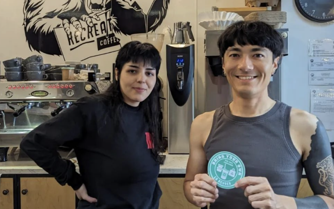 Owners at Recreational Coffee holding LB Reuses sticker.