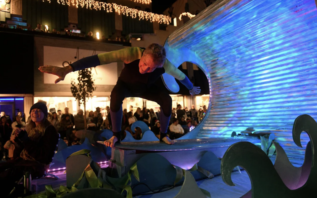 Capt. Moore surfing a wave on a float in the Christmas parade.