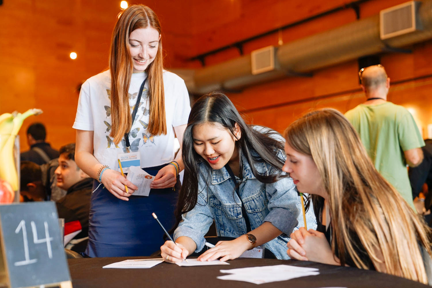 Students working together at a table taking notes.