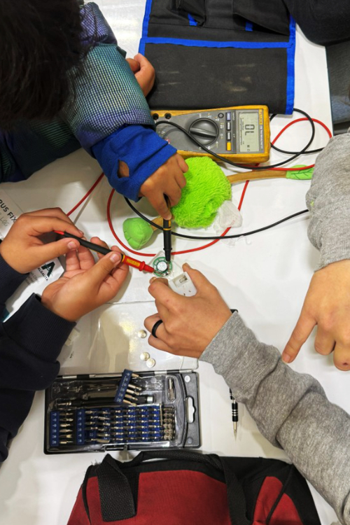 Students and Volunteer fixing a toy